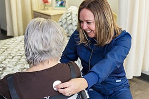 A nurse with an elderly resident at Delhi Post-Acute facility